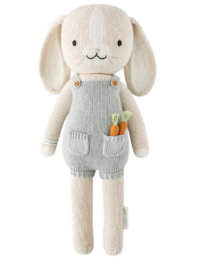 Cuddle and Kind handmade bunny wearing blue overall shorts with carrots in pocket